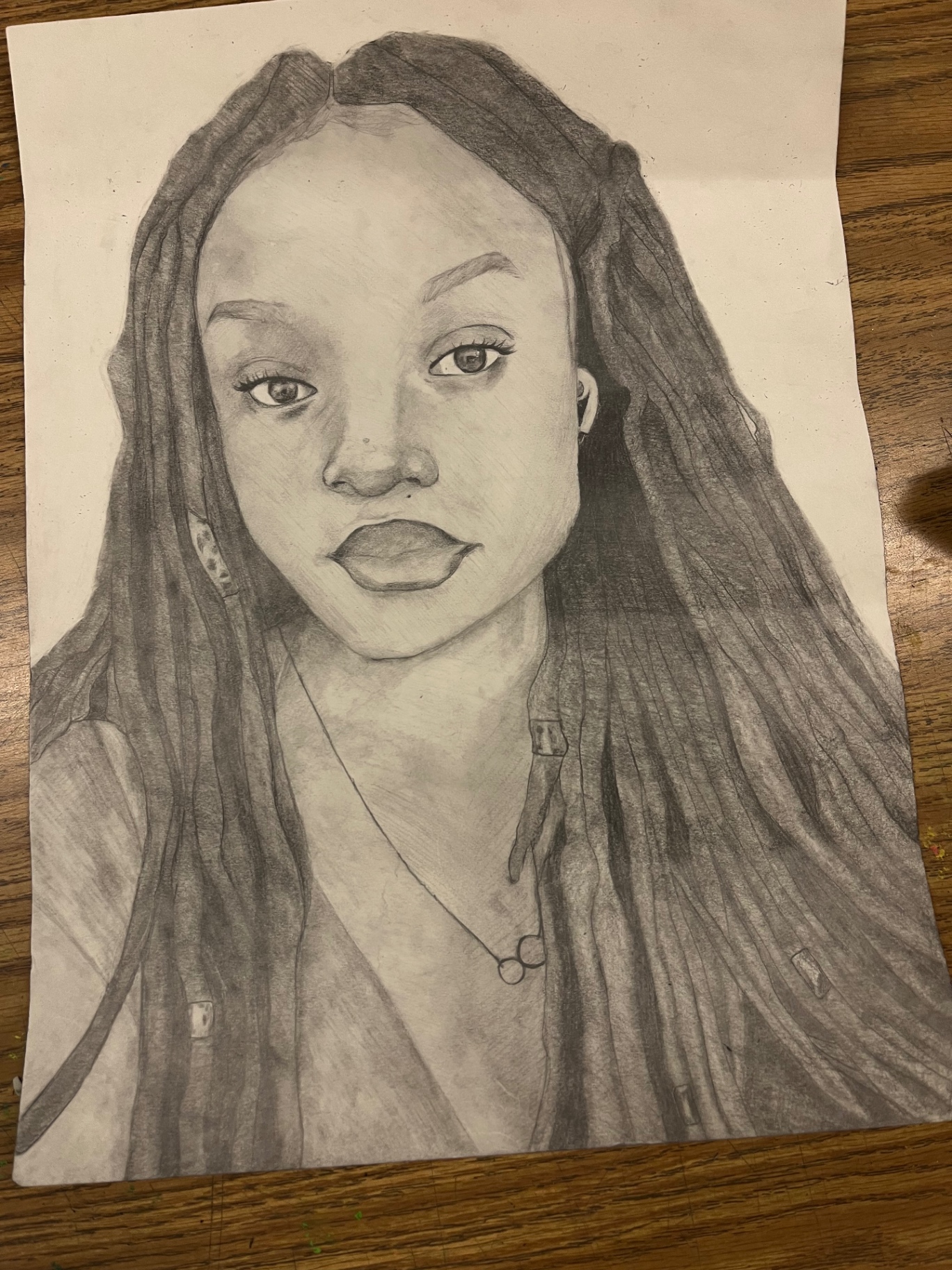 Pencil self portrait of Anabelle Hammons with long locs and a fine chain necklace